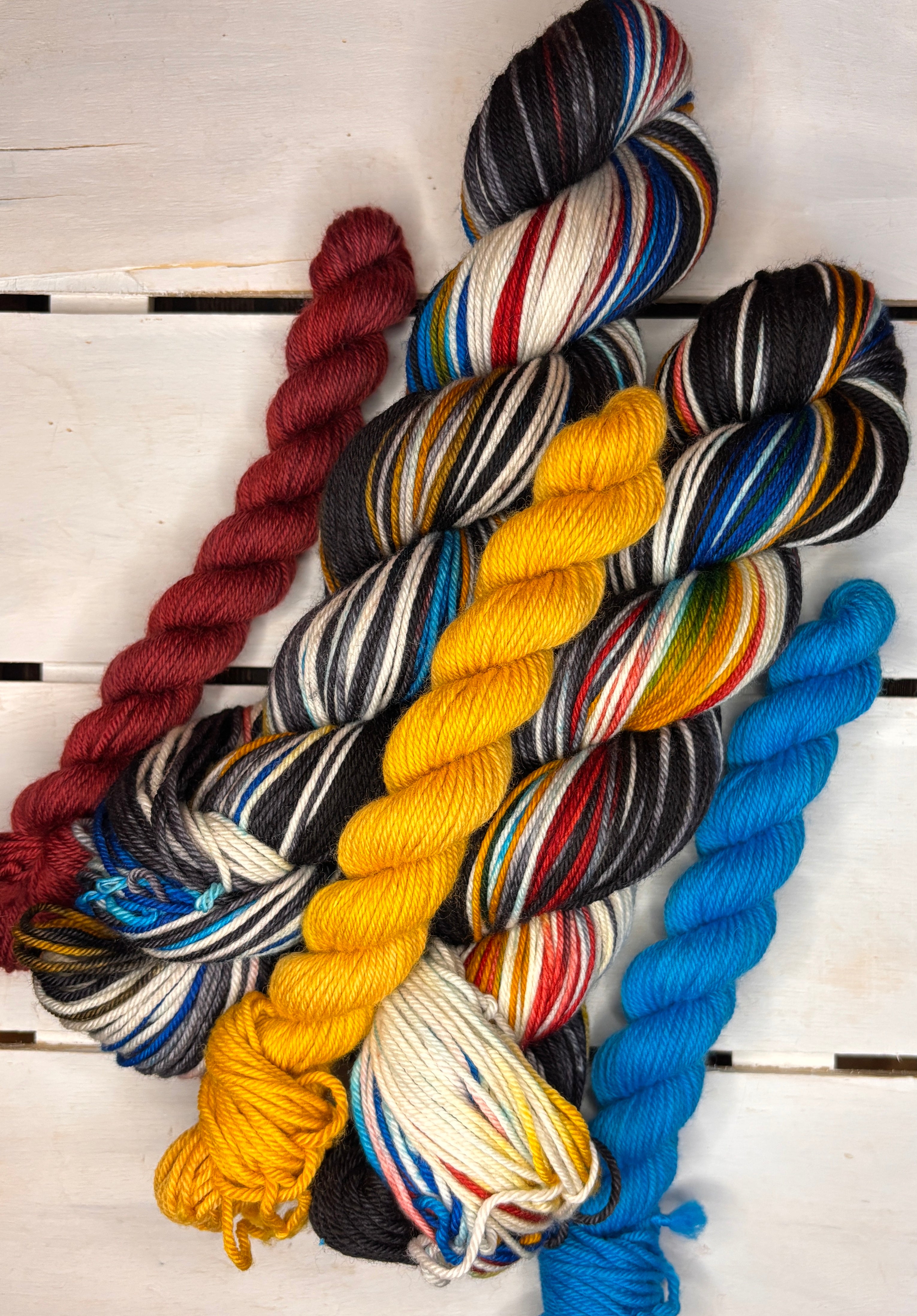 CMC logo, black red yellow blue varigated merino wool, DK Fingering