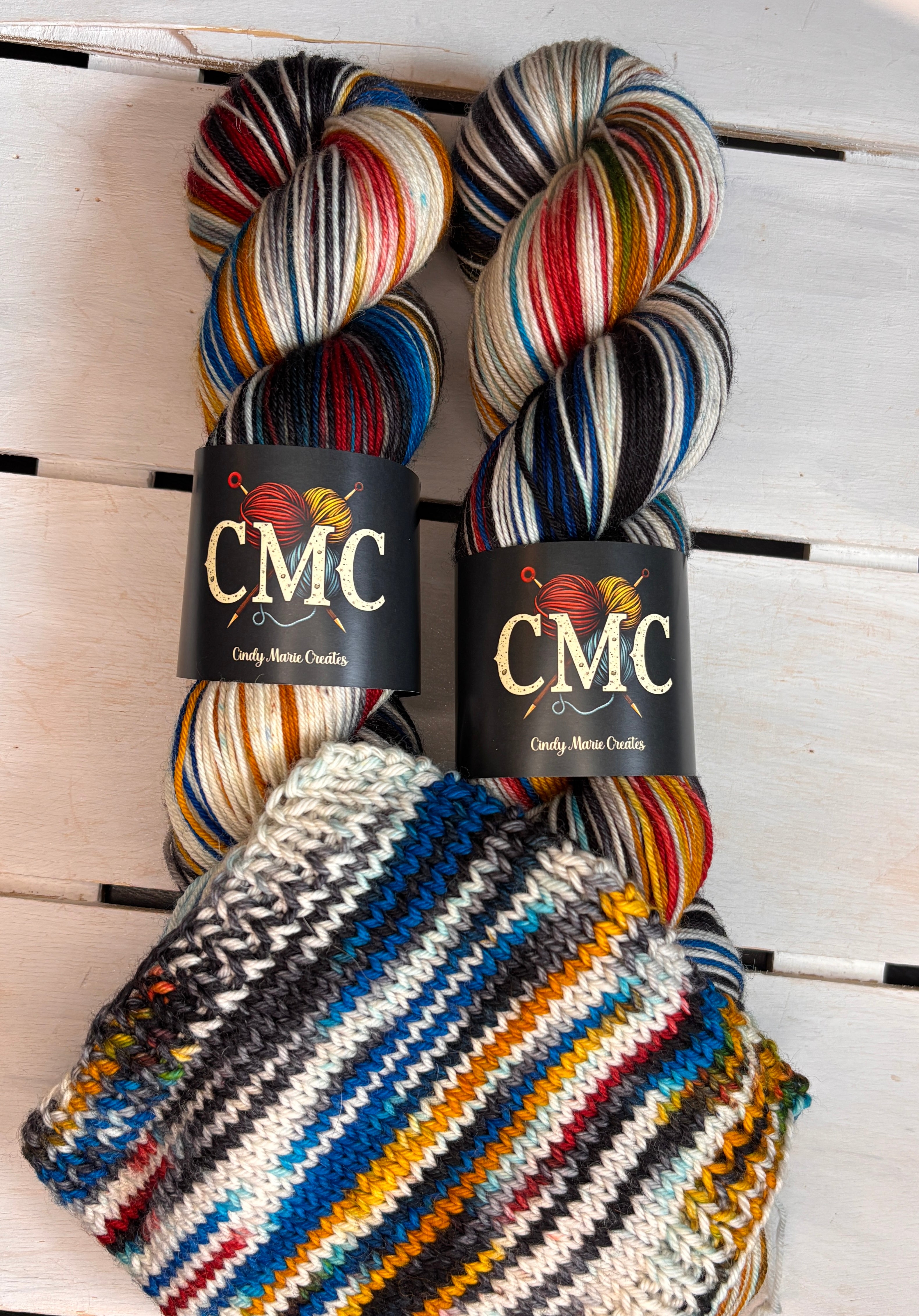 CMC logo, black red yellow blue varigated merino wool, DK Fingering